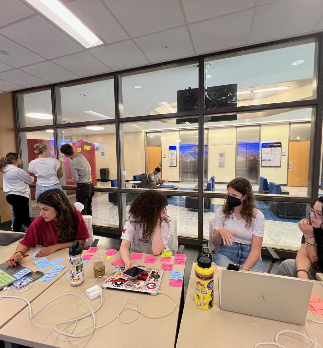 students working on computer with sticky notes